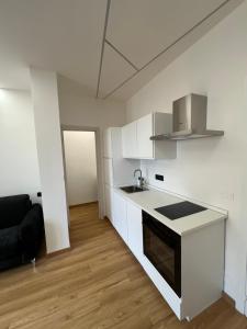 a kitchen with white cabinets and a black and white counter at Alloggio Manzoni in Asti