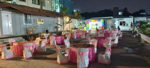 a group of tables with pink and white chairs at Himalaya Pool & Resort Hotel in Tirupati