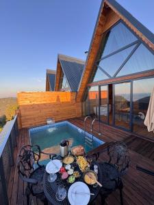 a table and chairs on a deck next to a pool at Defne Bungalow Yomra in Yomra
