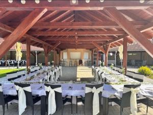 a long banquet hall with white tables and chairs at Hotel Allvet in Drnovice