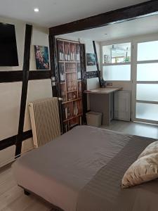 a bedroom with a bed and a desk in it at Passage des Romains studio in Horbourg