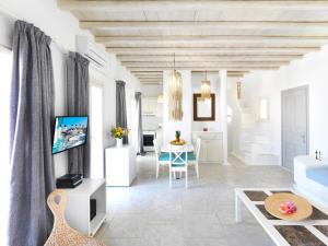 a white living room with a table and a couch at Parfait Villa, Mykonos in Agios Ioannis Mykonos