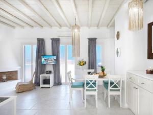 a white dining room with a table and chairs at Parfait Villa, Mykonos in Agios Ioannis Mykonos