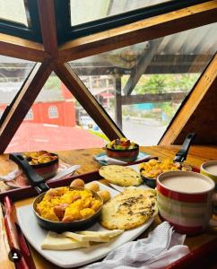 a table with a plate of breakfast food on it at Glamping Ibanazk in Ibagué