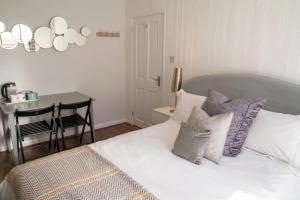 a bedroom with a bed with pillows and a table at Sunny Homestay Room, 10 Mins North Laine, 6 Mins Station in Brighton & Hove +17 photos