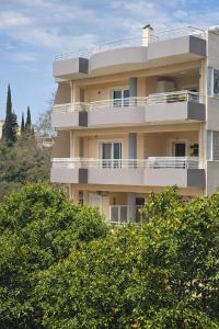 a tall building with trees in front of it at Studios Theodore in Kalamata