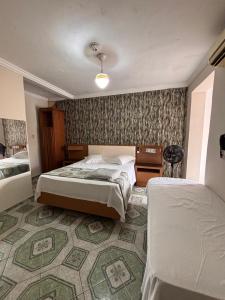 a hotel room with two beds and a carpet at Hospedaria Monumento in São Paulo