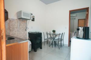 a kitchen with a stove and a table with chairs at Residencial Antônio Floriza in Sinop
