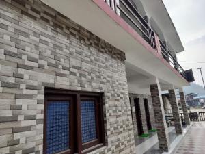 a brick building with a door on the side of it at Hotel Shri Yamuna Gaulok Dham in Kharsālī