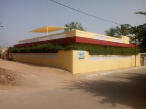 a yellow building with plants on the side of it at Appartement Keur Diam Saly in Saly Portudal