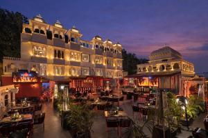 a hotel with tables and chairs in front of a building at Shakuntalam Sagar - Luxury Boutique Lake View Hotel, Udaipur in Udaipur