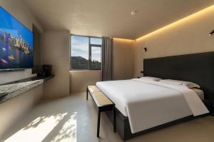 a bedroom with a large bed and a large window at Bay Four Seasons Castle Hotel in Weihai