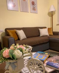 a living room with a couch and a table with flowers at Villa Colline Fiorite in Putignano +26 photos