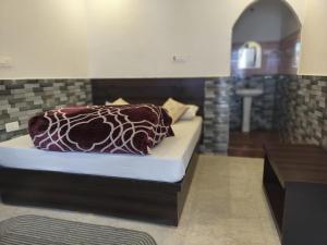 a bed with a pillow on it in a room at Hotel Shri Yamuna Gaulok Dham in Kharsālī