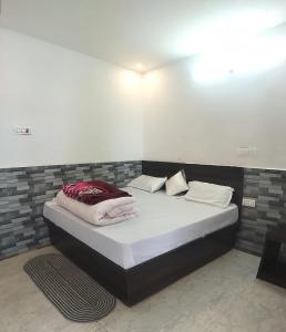 a bed with white sheets and pillows in a room at Hotel Shri Yamuna Gaulok Dham in Kharsālī +8 photos