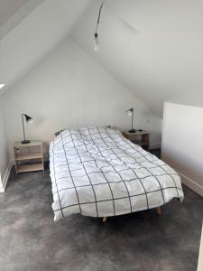 ein Bett in einem Zimmer mit zwei Nachttischen und zwei Lampen in der Unterkunft Le Bachelin in Saint-Omer