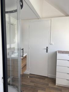 ein Badezimmer mit Glastür und Waschbecken in der Unterkunft Le Bachelin in Saint-Omer