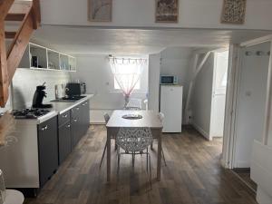 eine Küche mit Tisch und Esstisch in der Unterkunft Le Bachelin in Saint-Omer