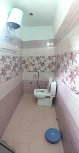 a pink bathroom with a toilet and a sink at Hotel Shri Yamuna Gaulok Dham in Kharsālī