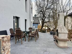 a patio with a table and chairs and a fireplace at Backstage, stylische Unterkunft mit Whirlpool in Dahlem