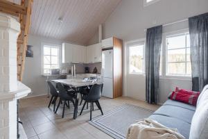 a kitchen and living room with a table and chairs at Villa Magnolia 1 Himos in Jämsä +19 photos