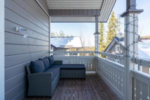 a porch with a couch on a wooden deck at Villa Magnolia 1 Himos in Jämsä