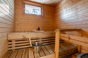 a sauna with a bucket in a wooden cabin at Villa Magnolia 1 Himos in Jämsä