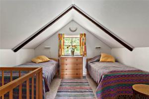 a attic bedroom with two beds and a window at KRO048-Urshult-Vaesterbotorp-Bosgard in Urshult