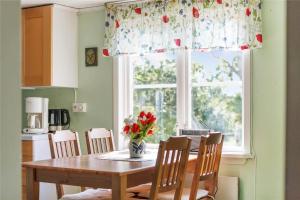 a dining room table with a vase of flowers and a window at KRO048-Urshult-Vaesterbotorp-Bosgard in Urshult