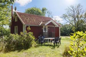 a red house with a table and chairs in front of it at KRO048-Urshult-Vaesterbotorp-Bosgard in Urshult