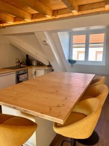 a kitchen with a wooden table and chairs at Le Nid de Schatzi in Haguenau +8 photos