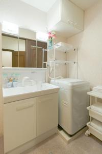 a bathroom with a sink and a toilet and a mirror at 逸泊居 in Osaka