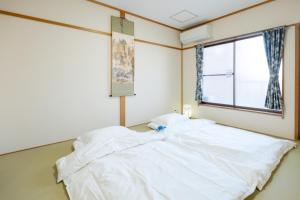 a large white bed in a room with a window at 逸泊居 in Osaka