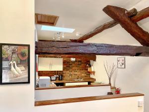 a kitchen with wooden beams on the ceiling at Rebecca Puddle Duck Cottage in Bassenthwaite