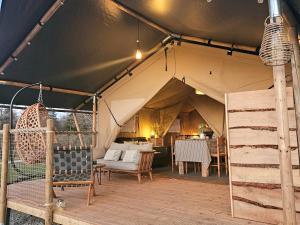 a tent with a table and chairs in it at Le Ranch Camping et Glamping in Madranges