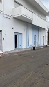 a white building with a parking lot in front of it at Camere a Sud in Alliste