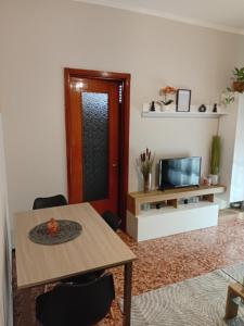 a living room with a table and a tv at Alloggio Veronica in Voghera +7 photos
