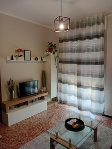 a living room with a television and a table at Alloggio Veronica in Voghera