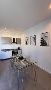 a kitchen with a glass table and chairs at CR Home in Palermo