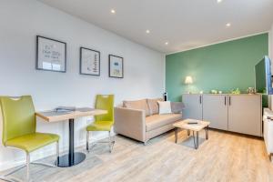 a living room with a couch and a table and chairs at Schmidt-einander W10 in Norderney
