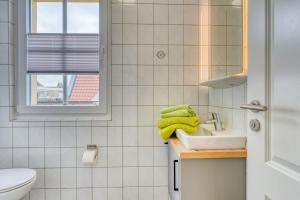 a bathroom with a sink and a toilet at Schmidt-einander W10 in Norderney +4 photos