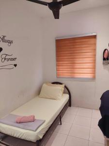 a bed in a room with a window at Abadi Homestay Ipoh in Ipoh