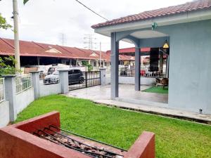 a yard with a bench in front of a house at Abadi Homestay Ipoh in Ipoh +3 photos