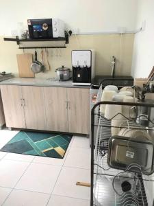 a kitchen with wooden cabinets and a counter top at Abadi Homestay Ipoh in Ipoh