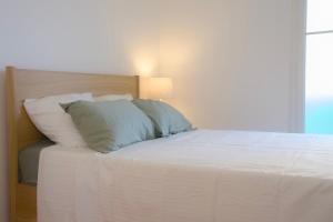 a bedroom with a bed with white sheets and pillows at Chez Leela in Poissy