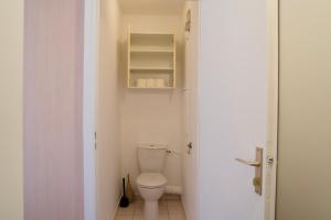 a bathroom with a toilet in a small room at Chez Leela in Poissy +23 photos