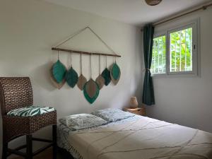 a bedroom with a bed and a chair and a window at Villa Coco Caraïbes in Deshaies