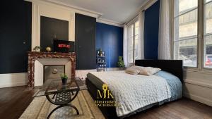 a bedroom with blue walls and a bed and a fireplace at Le Bleuet Boulevard de la Rochelle, centre-ville in Bar-le-Duc