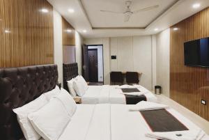 a hotel room with two beds and a flat screen tv at U LIFE HOTEL in Mumbai +33 photos