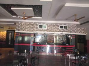a bar in a restaurant with tables and chairs at Hotel O Snenanjali in Kolkata